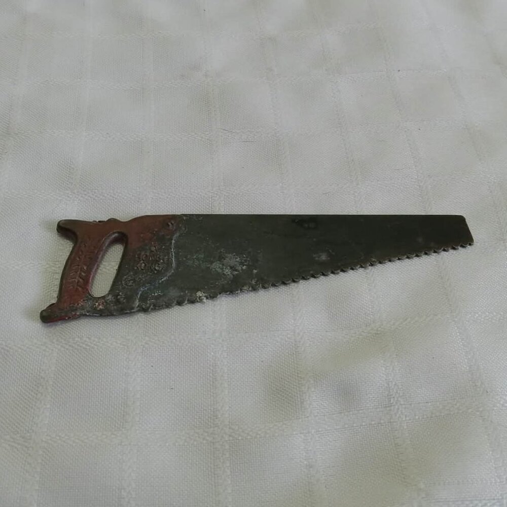 Fake toy shaped like a hand saw made of metal vintage and functional